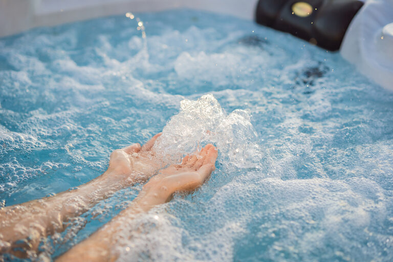 Portrait of young carefree happy smiling woman relaxing at hot tub during enjoying happy traveling moment vacation life against the background of green big mountains